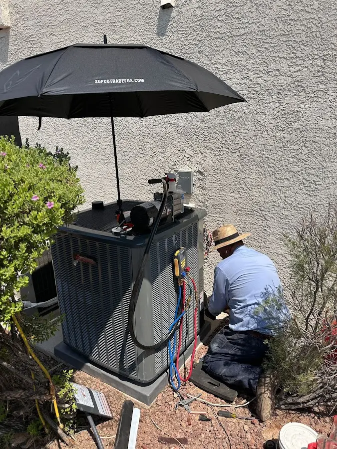 HVAC technician performing outdoor AC maintenance in Weare